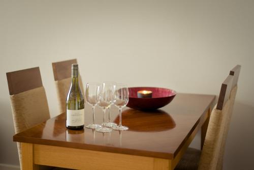 a bottle of wine sitting on a table with wine glasses at PREMIER SUITES Dublin, Sandyford in Sandyford
