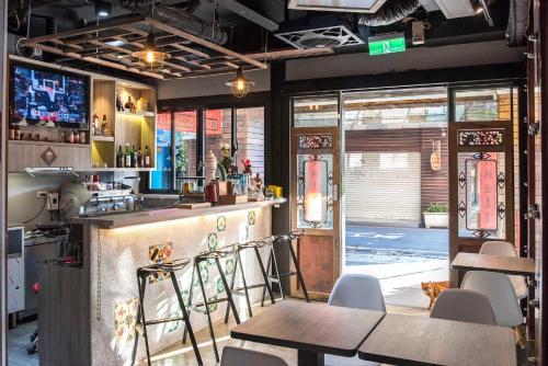 a restaurant with a bar with tables and chairs at Old Door Hostel & Bar in Taipei