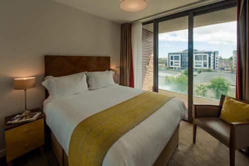 ein Hotelzimmer mit einem großen Bett und einem Fenster in der Unterkunft PREMIER SUITES Dublin, Sandyford in Sandyford