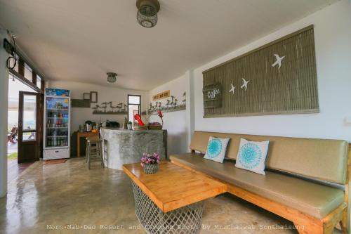 a living room with a bench and a kitchen at Norn Nab Dao RimPhu Resort in Chiang Khan