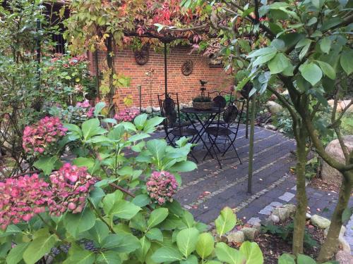 a garden with a table and some pink flowers at Haus am See in Schiffdorf