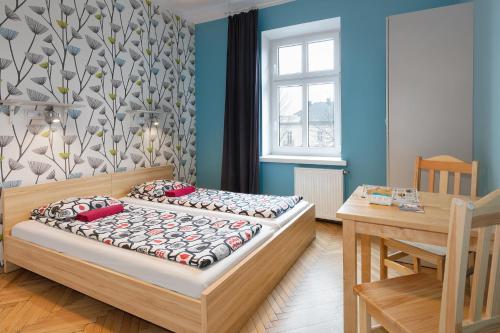a small bedroom with two beds and a table at Atlantis Hostel in Kraków