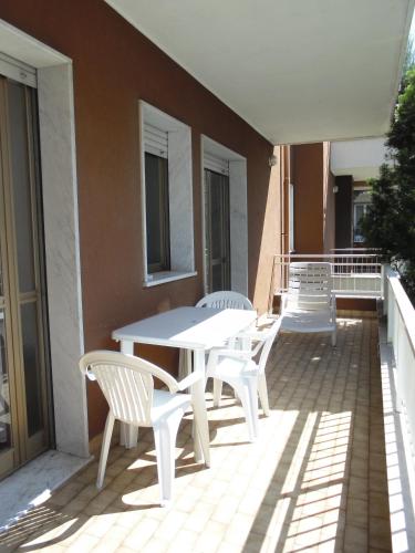 a patio with a white table and chairs on a balcony at Residence Aurora Wellness & Spa in Albenga