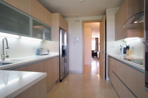 a kitchen with white counter tops and wooden cabinets at Ribera del Marlin - Sotogrande in Sotogrande