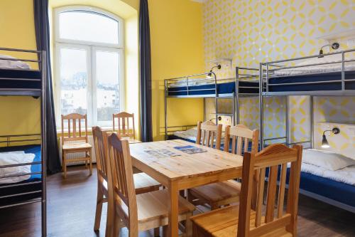 a dining room with a table and chairs and bunk beds at Atlantis Hostel in Kraków