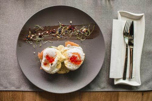 a plate of food on a table next to a fork at Mava Apartamente in Constanţa