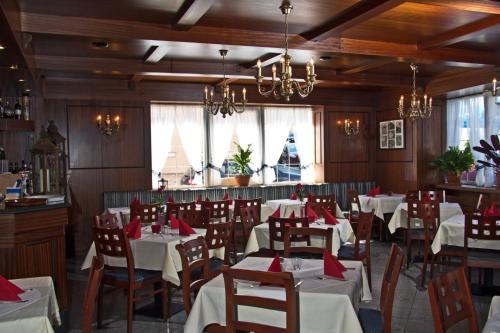 a restaurant with tables and chairs with red napkins at Hotel Albergo Mamma Rosa in Wunsiedel