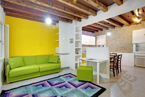 salon z zieloną kanapą i stołem w obiekcie Fenix Otello Apartments w Wenecji