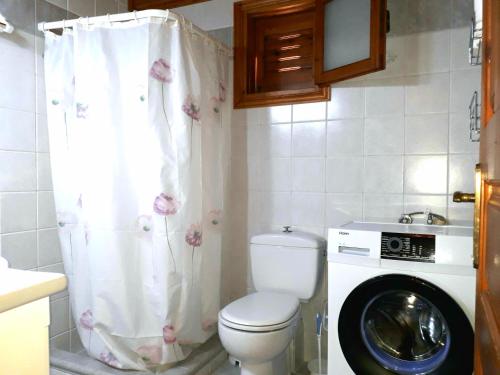 a bathroom with a toilet and a washing machine at Sirius House in Finikounta
