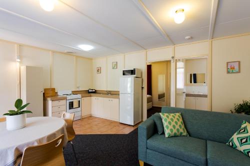 a kitchen and living room with a couch and a table at Park Avenue Holiday Units in Albany