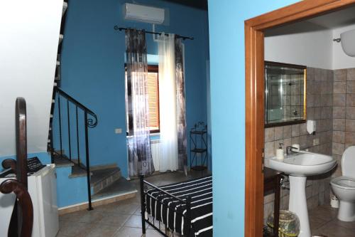 a bathroom with blue walls and a sink and a staircase at A CASA DI ANNA in Cerveteri