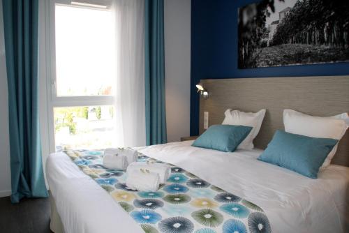 Un pat sau paturi într-o cameră la Résidence Vacances Bleues Les Coteaux de Jonzac