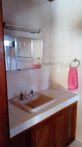 W łazience znajduje się umywalka i lustro. w obiekcie Pousada Arco Íris w mieście Tabapira