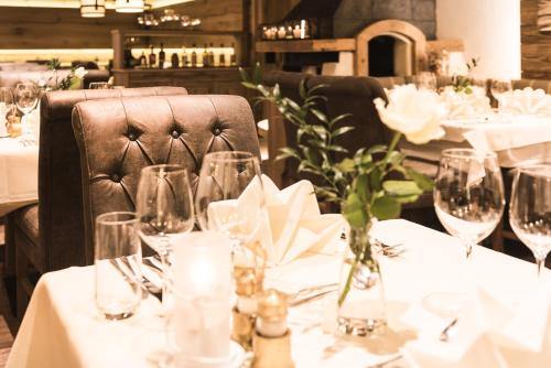 a table with glasses and a chair in a restaurant at Sepp & Hannis Suiten im Dorf in Neustift im Stubaital