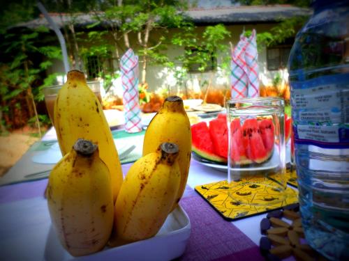 three bananas in a bowl on a table with watermelon at Grand freedom in Sigiriya