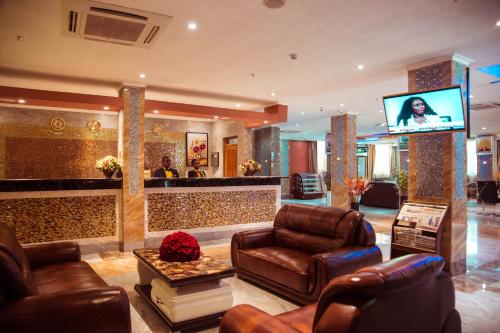 a living room with leather furniture and a television at Tiffany Diamond Hotels LTD - Makunganya in Dar es Salaam