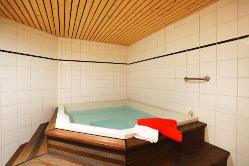 La salle de bains est pourvue d'une baignoire et d'une serviette rouge. dans l'établissement Résidence Néméa Le Nevez, aux Contamines-Montjoie