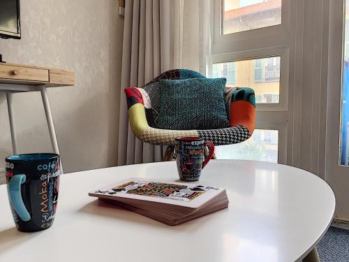 une chaise assise au-dessus d'une table avec un livre dans l'établissement Nestor&Jeeves - NEVADA SUITE - Central - Close sea, à Nice