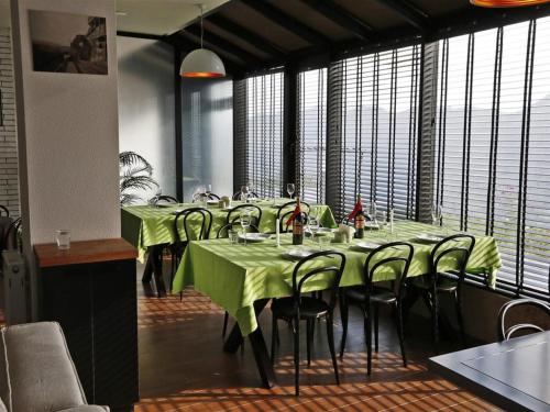 a dining room with green tables and chairs and windows at 2-room Apartment Gudauri Penta 303 in Gudauri