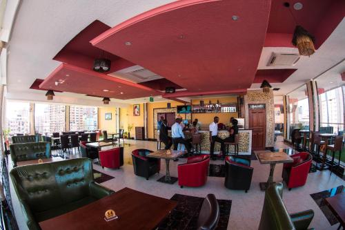 a restaurant with red ceilings and tables and chairs at Tiffany Diamond Hotels LTD - Makunganya in Dar es Salaam