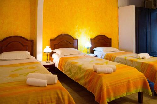 Habitación de hotel con 3 camas y toallas. en Hotel & Restaurante Guarania, en Ciudad del Este