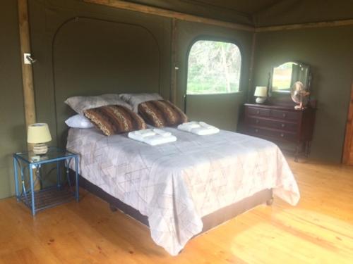 a bedroom with a bed with two towels on it at Hillcrest Lodge Tents - Sandstone in Plettenberg Bay