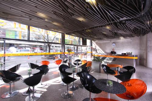 a restaurant with black and orange chairs and tables at Design Metropol Hotel Prague in Prague