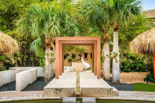 a bride and groom standing in a doorway in a garden at Sanctuary Cap Cana, a Luxury Collection Resort, Dominican Republic, Adult All-Inclusive in Punta Cana