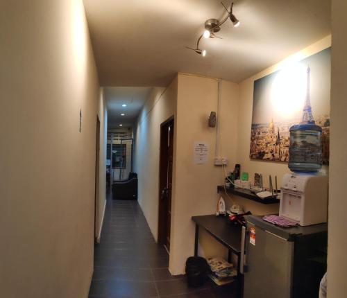 a hallway leading to a room with a kitchen and a microwave at StarVilla Kinta River Front Medan Istana in Ipoh