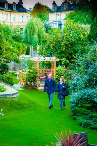 a man and woman walking through a garden at Oldfields House in Bath