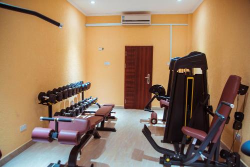 a gym with rows of exercise equipment in a room at Tiffany Diamond Hotels LTD - Makunganya in Dar es Salaam