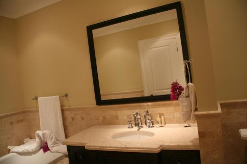 a bathroom with a sink and a mirror and a toilet at The Atrium Resort in Grace Bay