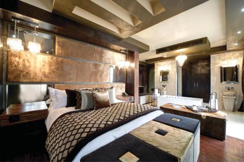 a bedroom with a large bed and a bathroom at Palala Boutique Game Lodge and Spa in Tom Burke