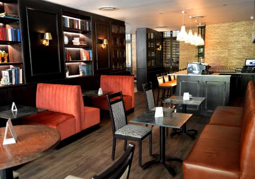 a restaurant with orange chairs and tables and a bar at Royal Palm Hotel in Durban