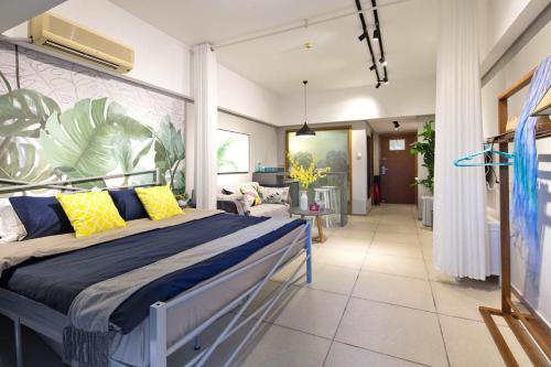 Sanya Sanya Bay·Sanya Bay Tourist Area· Locals Apartment 00164300 في سانيا: غرفة نوم بسرير مع مخدات صفراء و زرقاء