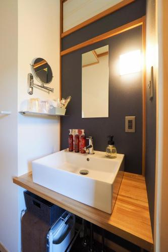 a bathroom with a white sink and a mirror at Arai Ryokan in Izu