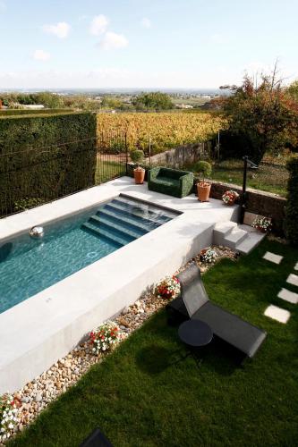 a swimming pool in a yard with a table and a bench at Auberge Du Paradis in Saint-Amour-Bellevue
