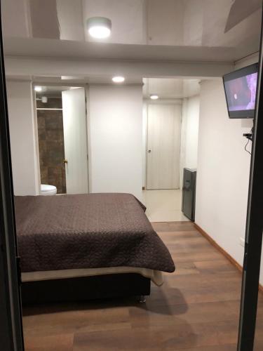 1 dormitorio con 1 cama y TV de pantalla plana en Apt nororiente 203, en Bogotá