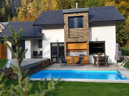 a house with a swimming pool in front of it at Hiša Katja-Privat wellness in Kranjska Gora