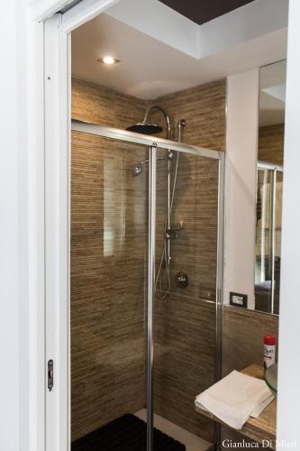 a shower in a bathroom with wooden walls at Mongibello Palace B&B in Mondello