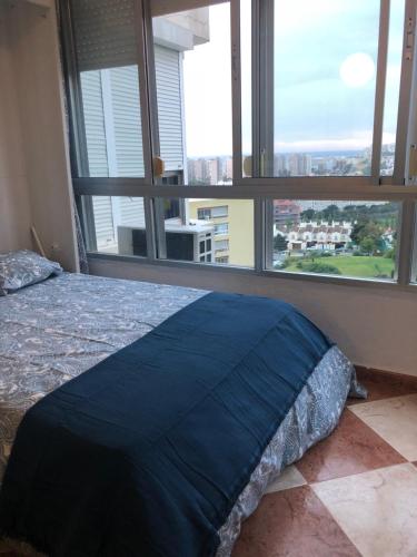トレモリノスにあるMagnifico Apartamento Playamarのベッドルーム1室(ベッド1台、大きな窓付)