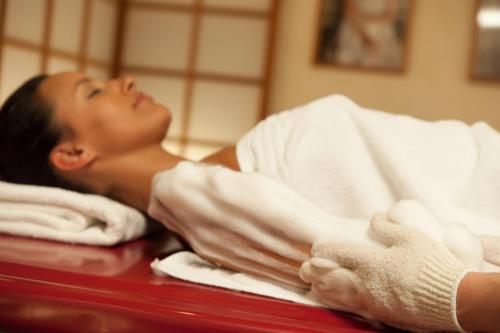 a woman laying in a bed under a towel at Chalet Silvretta Hotel & Spa in Samnaun