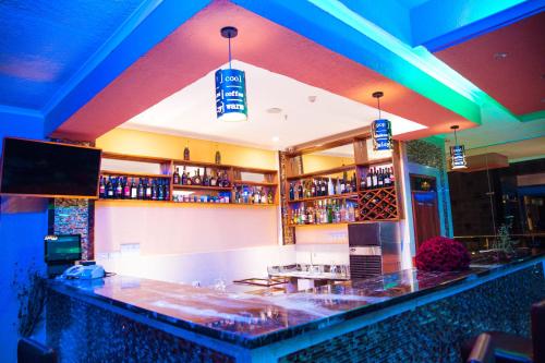 a bar in a restaurant with blue lights at Tiffany Diamond Hotels LTD - Makunganya in Dar es Salaam