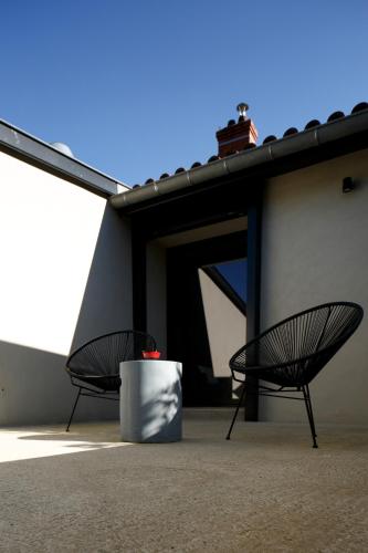 two black chairs sitting next to a building at Auberge Du Paradis in Saint-Amour-Bellevue
