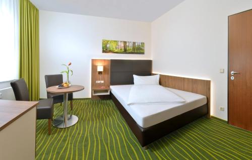 a hotel room with a bed and a table at Hotel Meyer in Glauchau