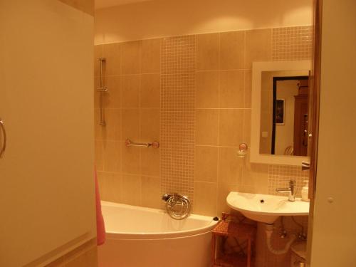 a bathroom with a tub and a sink and a bath tub at Apartments Meixner in Mariánské Lázně