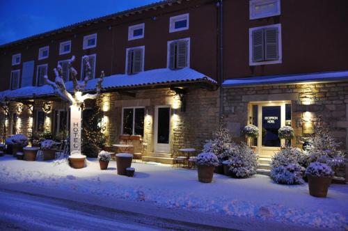 a building with snow on the ground in front of it at Auberge Du Paradis in Saint-Amour-Bellevue