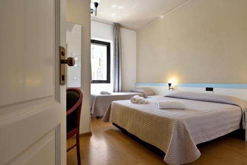 a hotel room with two beds and a window at Hotel Orri in Tortolì