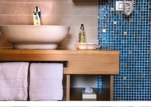 ein Badezimmer mit einem Waschbecken und einer Theke mit Handtüchern in der Unterkunft Hotel Lago Di Garda in Malcesine