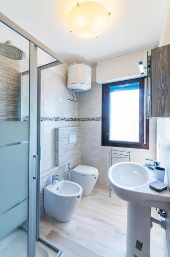 a bathroom with a sink and a tub and a toilet at Columbus in Bibione
